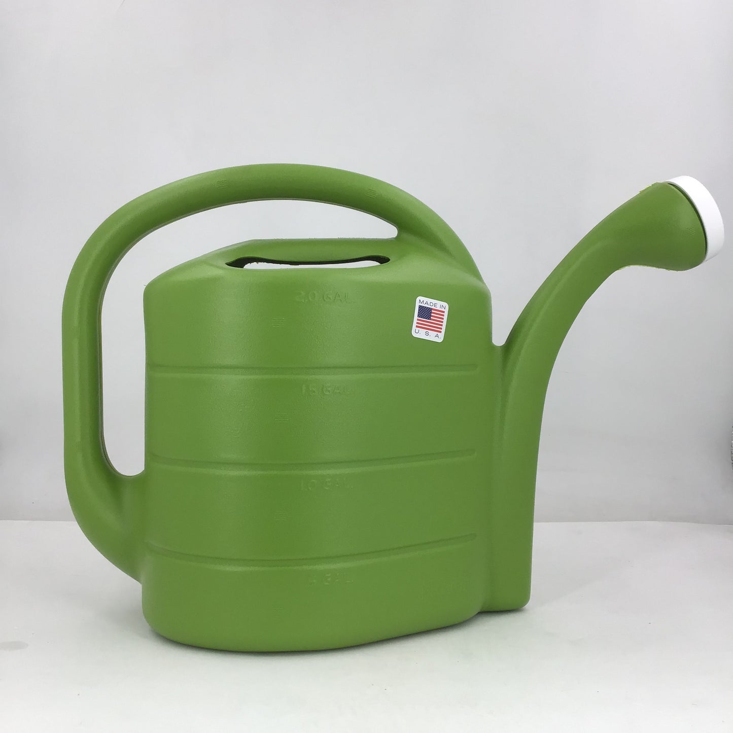 Green watering can with a white handle on a light gray background