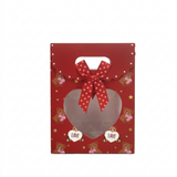 Red gift box with a heart-shaped window, teddy bears, and a polka dot ribbon on a white background.