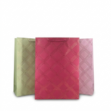 Three patterned paper bags in green, pink, and red on a white background