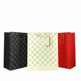 Three quilted gift bags in black, white, and red on a white background