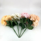 Bouquet of artificial flowers in peach, white, and pink on a white background