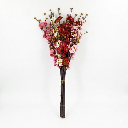 Bouquet of artificial flowers with red, pink, and white blossoms on a white background