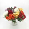 Bouquet of colorful artificial flowers in a clear vase on a white background