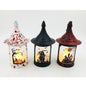 Three Halloween witch-house lanterns with pointed roofs, shown side by side on a white background. The left lantern is white with red splatter and a pumpkin-and-tree design, the middle lantern is black with a skeleton-and-horror scene, and the right lantern is dark red with a haunted-house design.