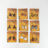 Nine pairs of Halloween-themed dangle earrings displayed on matching orange backing cards against a plain white background. The designs include witches, pumpkins, mummies, skulls, ghosts, and a witch-and-pumpkin pair, each with 'HAPPY HALLOWEEN' printed on its card.