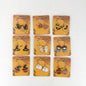 Nine pairs of Halloween-themed dangle earrings displayed on matching orange backing cards against a plain white background. The designs include witches, pumpkins, mummies, skulls, ghosts, and a witch-and-pumpkin pair, each with 'HAPPY HALLOWEEN' printed on its card.