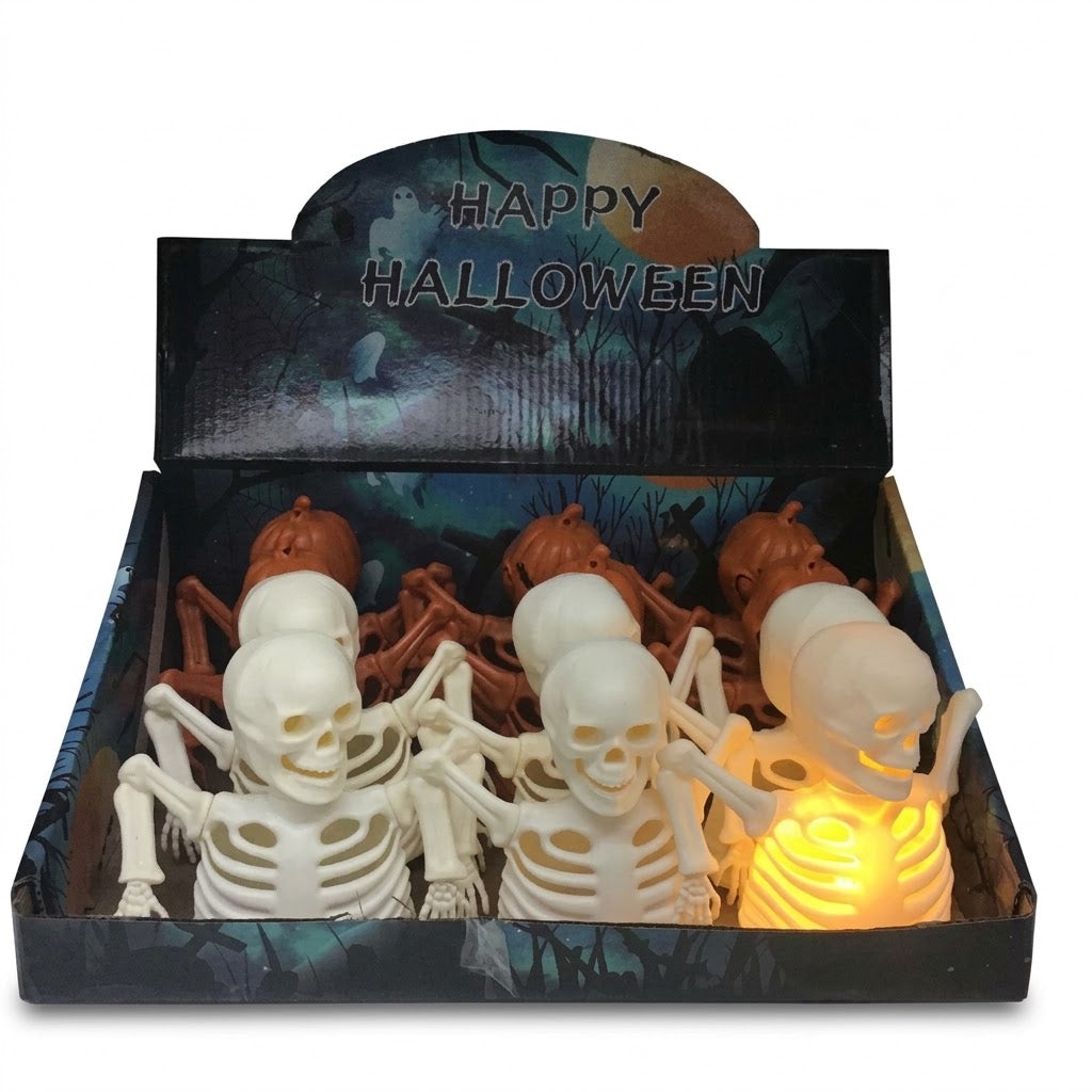 A Halloween display box filled with plastic skeleton decorations, including two white skeletons in front, several brown skeletons behind, and one glowing lighted skeleton on the right. The open box has a Halloween-themed printed insert reading 'Happy Halloween' on a white background.