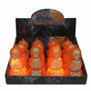 A retail display box filled with small Halloween skeleton ornaments that glow orange. The display header reads “HAPPY HALLOWEEN” over a dark spooky background, and the skeletons inside are illuminated from within.