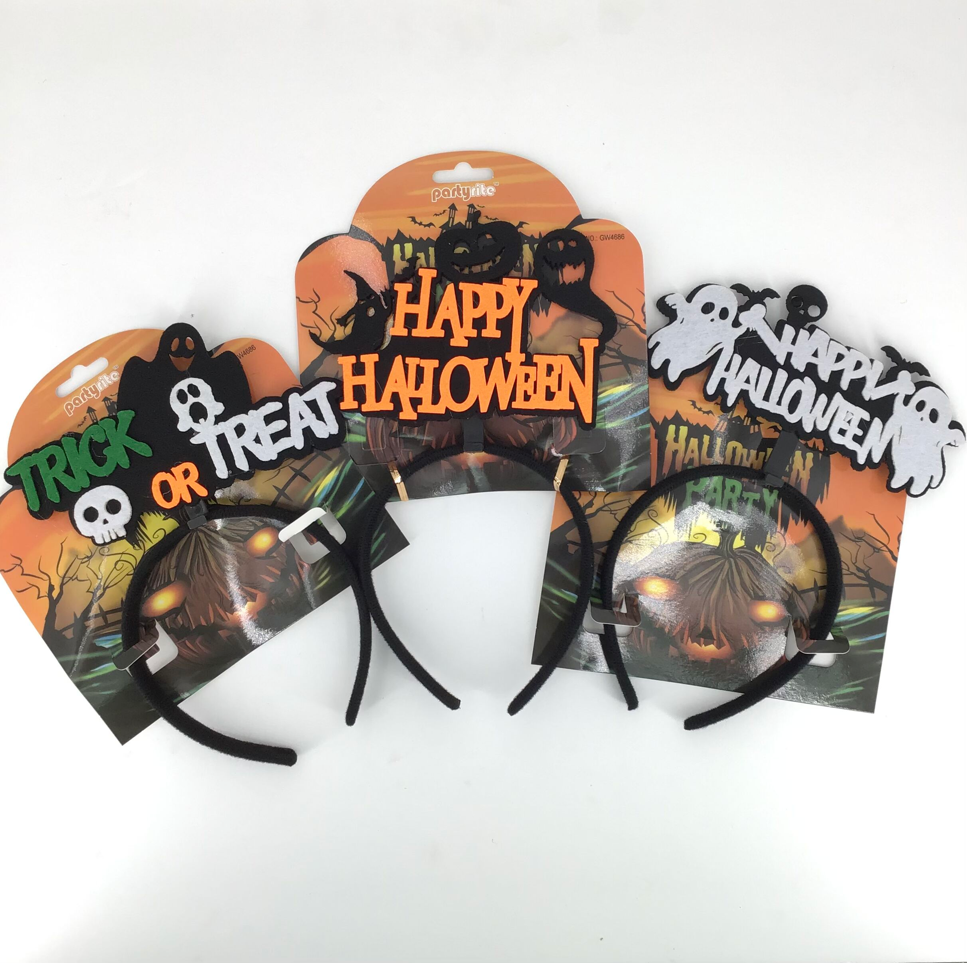 Three Halloween headbands on their retail backing cards, one reading 'HAPPY HALLOWEEN' and the other 'TRICK OR TREAT HALLOWEEN PARTY', both with black ghost and pumpkin graphics.