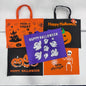 Four Halloween-themed fabric tote bags arranged on a white background: orange with black handles and spooky graphics, black with orange handles and 'Happy Halloween' text, purple with white ghost cutouts and 'Happy Halloween' text, and orange with black handles, jack-o'-lantern graphics, and 'Happy Halloween' text.