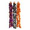 Three festive tinsel garlands hanging vertically on a plain white background, in purple and orange with gold accents, and in black and white with gold accents.
