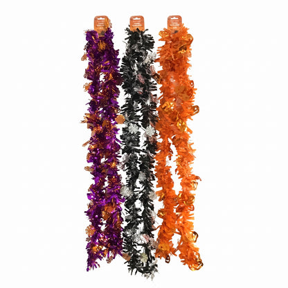 Three festive tinsel garlands hanging vertically on a plain white background, in purple and orange with gold accents, and in black and white with gold accents.