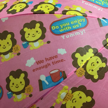 Pink umbrella with cartoon lion designs and text on a pink background