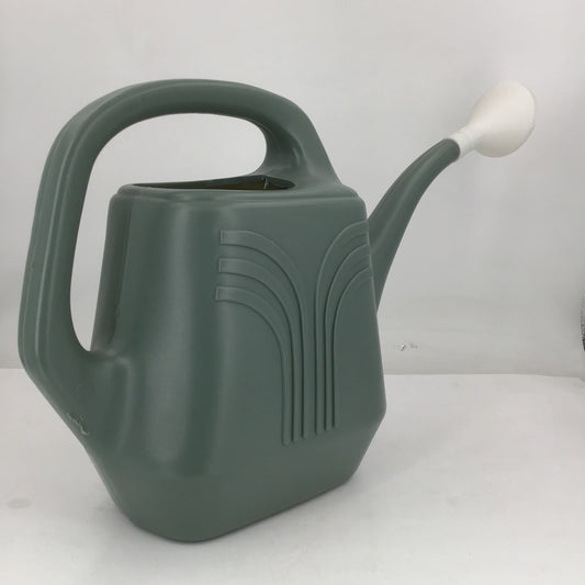 Green watering can with a white handle on a light gray background