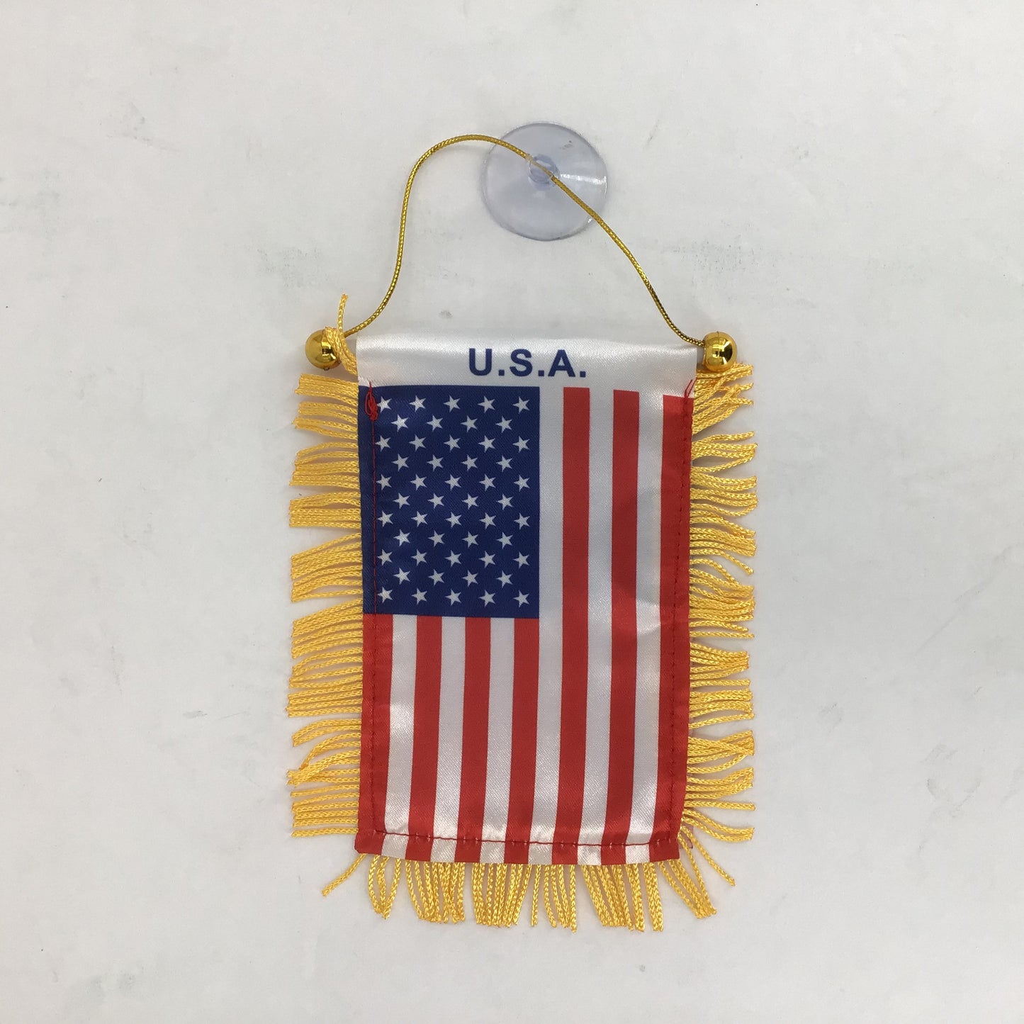 Small American flag with yellow fringe and 'U.S.A.' text on a white background