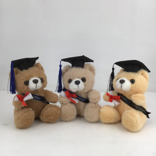 Three teddy bears wearing graduation caps and gowns on a white background
