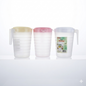 Three plastic pitchers with different colored lids on a white background