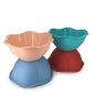 Four flower-shaped plastic mixing bowls stacked in pairs, shown in peach, teal, and red on a white background.