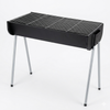 Black portable grill with metal legs on a white background