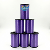 Purple curling ribbon spools stacked on a white background